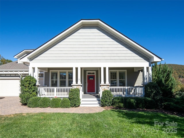 view of front facade with a porch, a garage, and a front lawn