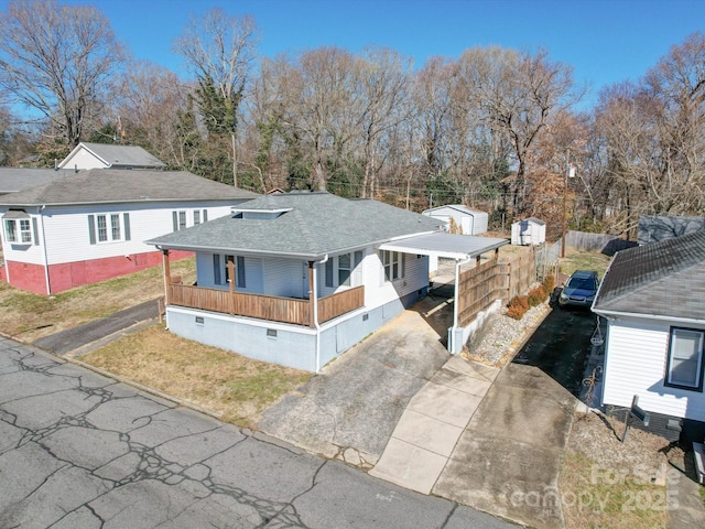 view of front of property featuring a carport, covered porch, and a storage shed