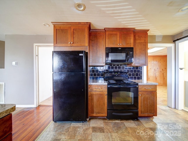 kitchen featuring decorative backsplash, black appliances, and light wood-type flooring