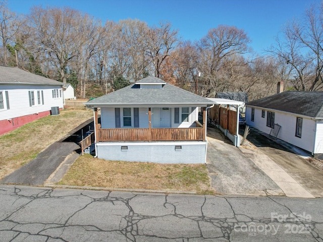 view of front of property featuring a porch, a carport, and a front lawn