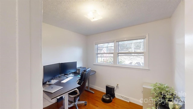 office space with wood-type flooring and a textured ceiling