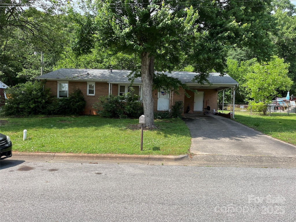 ranch-style home with a carport and a front lawn