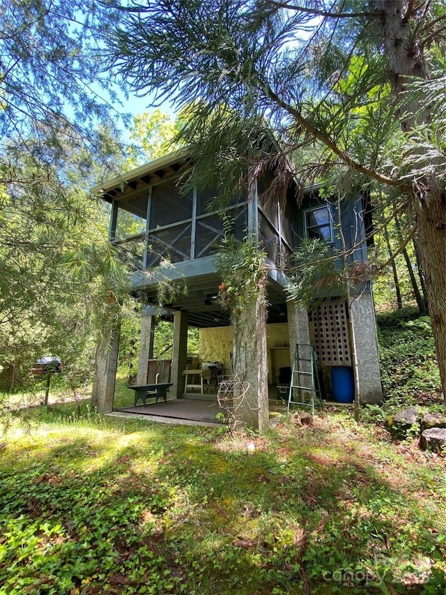 rear view of house with a patio area and a sunroom