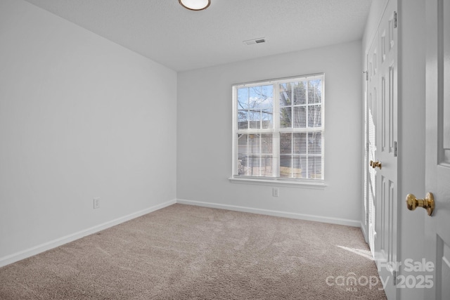 empty room with a textured ceiling and carpet flooring