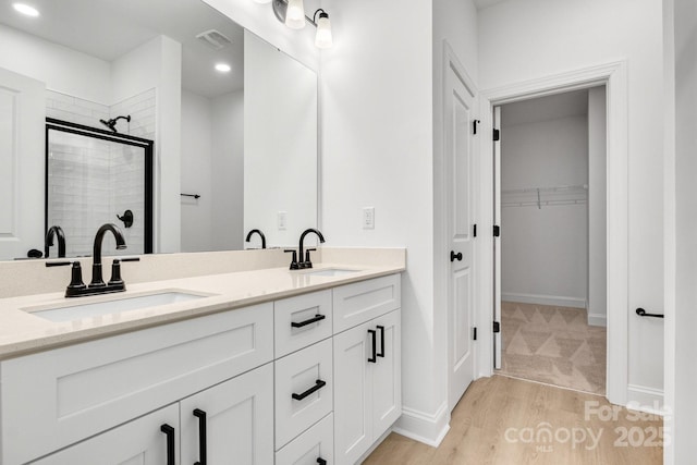 bathroom with vanity, hardwood / wood-style floors, and a shower with shower door