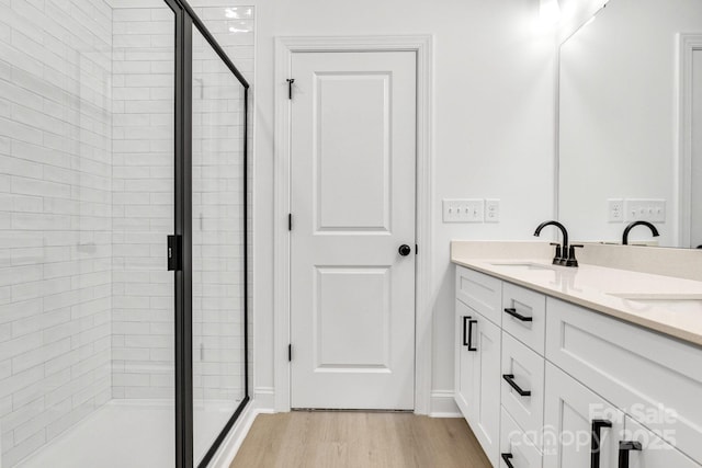 bathroom featuring vanity, wood-type flooring, and walk in shower