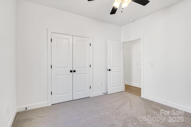 unfurnished bedroom with ceiling fan, a closet, and light carpet