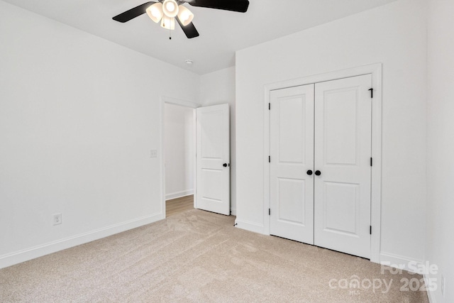 unfurnished bedroom featuring light carpet, ceiling fan, and a closet