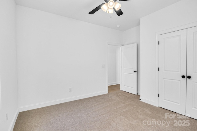 unfurnished bedroom with light carpet, ceiling fan, and a closet