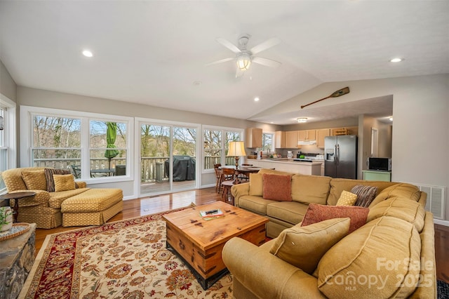 living room featuring ceiling fan, lofted ceiling, and light wood-type flooring