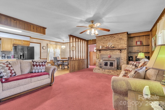 carpeted living room with ceiling fan, ornamental molding, and a textured ceiling