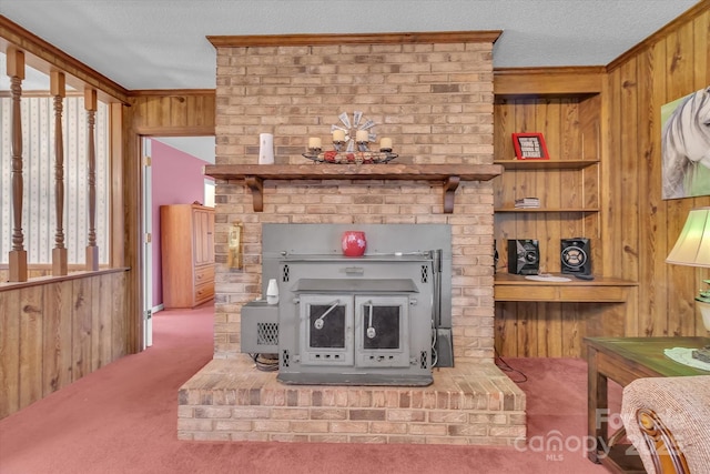 living room with carpet flooring, wooden walls, a textured ceiling, and a wood stove