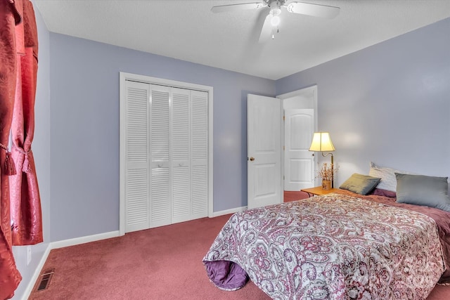 bedroom featuring ceiling fan, carpet flooring, a closet, and a textured ceiling