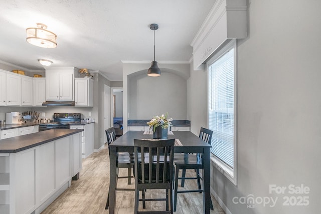 kitchen featuring black electric range oven, light hardwood / wood-style flooring, hanging light fixtures, and white cabinets