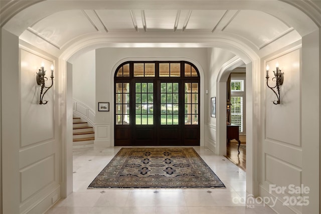 entryway with coffered ceiling and light tile patterned floors