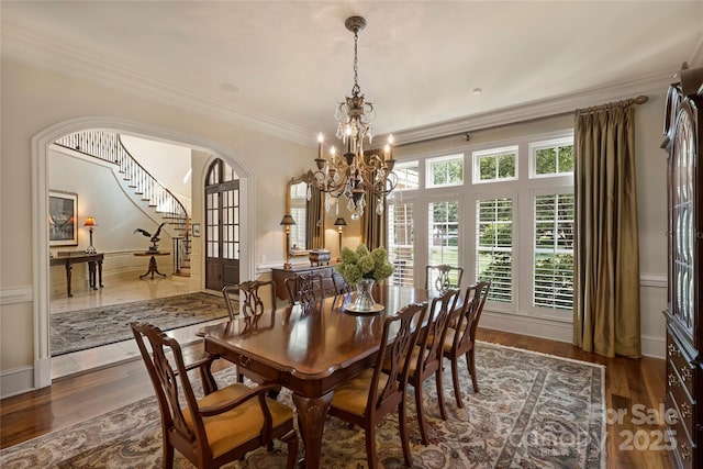 dining space with crown molding, a chandelier, and dark hardwood / wood-style flooring