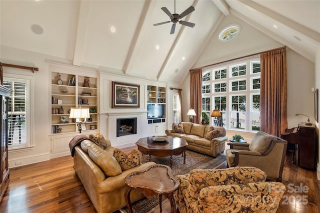 living room with hardwood / wood-style floors, high vaulted ceiling, beamed ceiling, and ceiling fan