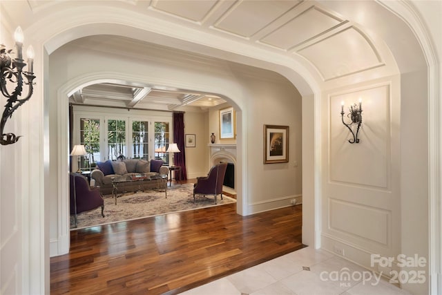 interior space with beamed ceiling, ornamental molding, coffered ceiling, and light tile patterned floors