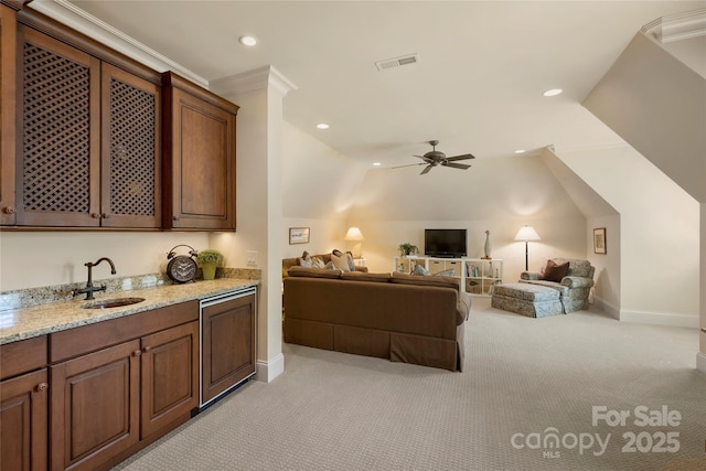 carpeted living room with ceiling fan, ornamental molding, sink, and lofted ceiling