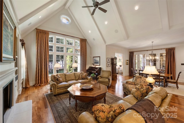 155 Union Chapel Dr, Mooresville, NC 28117 - living room featuring beamed ceiling, ceiling fan, light wood-style flooring, a fireplace with flush hearth, and a chandelier