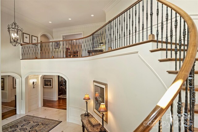 155 Union Chapel Dr, Mooresville, NC 28117 - stairway featuring a towering ceiling, a chandelier, arched walkways, ornamental molding, and recessed lighting