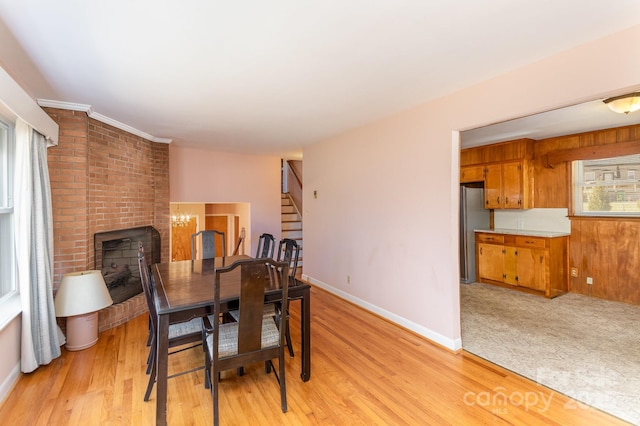 dining space featuring a fireplace and light wood-type flooring