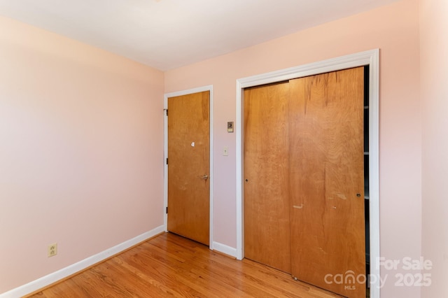 unfurnished bedroom with light hardwood / wood-style flooring and a closet