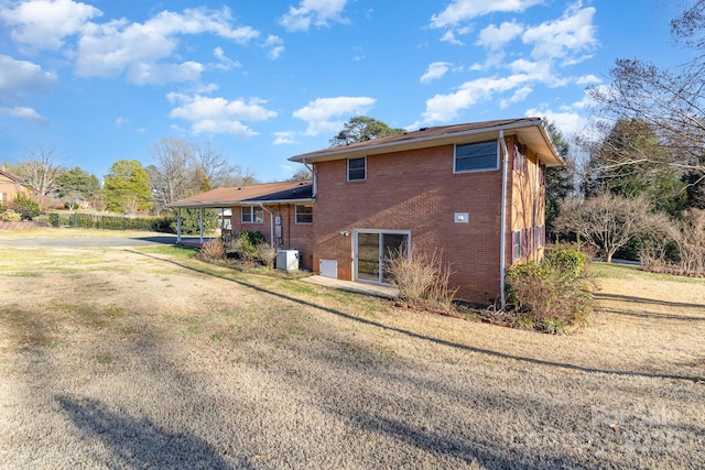 back of property featuring a lawn and central air condition unit