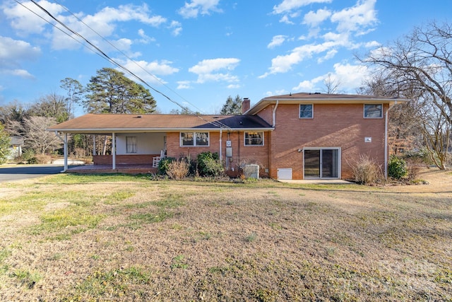 rear view of property with a lawn