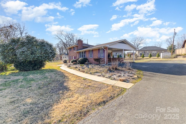 ranch-style home featuring a carport and a front yard