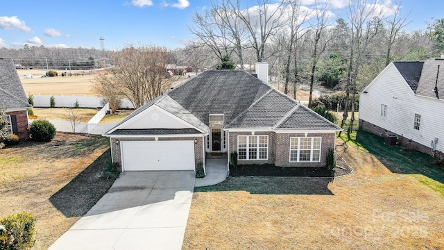 view of front of house with cooling unit, a garage, and a front yard