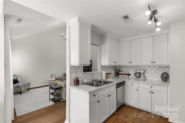 kitchen with wood-type flooring, dishwasher, sink, and white cabinets