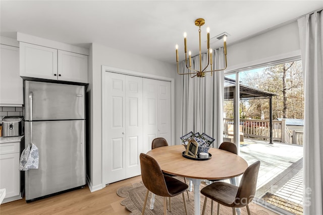 dining room featuring a notable chandelier and light wood-type flooring