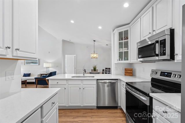 kitchen featuring pendant lighting, sink, stainless steel appliances, and white cabinets