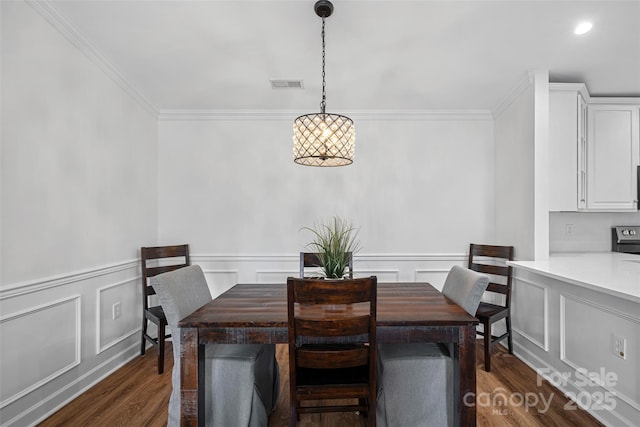 dining space with dark hardwood / wood-style flooring and crown molding