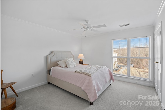 bedroom featuring ornamental molding, light colored carpet, and ceiling fan