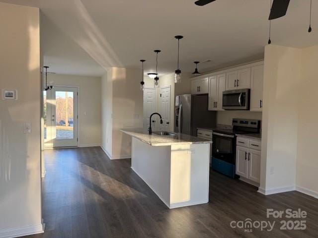 kitchen with decorative light fixtures, white cabinetry, sink, a kitchen island with sink, and stainless steel appliances