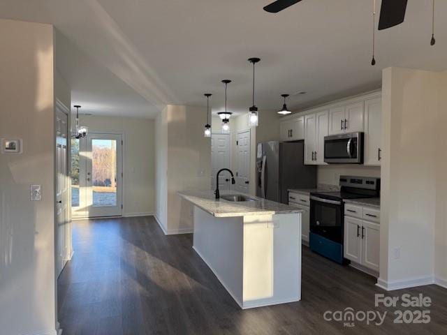 kitchen with appliances with stainless steel finishes, decorative light fixtures, white cabinetry, a kitchen island with sink, and dark wood-type flooring