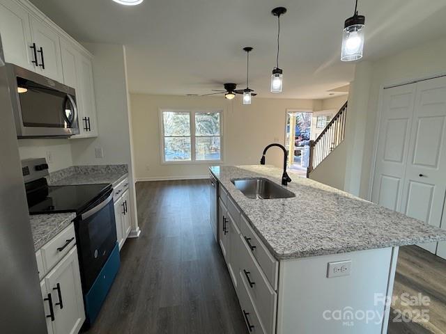 kitchen featuring sink, white cabinetry, a kitchen island with sink, stainless steel appliances, and dark hardwood / wood-style flooring