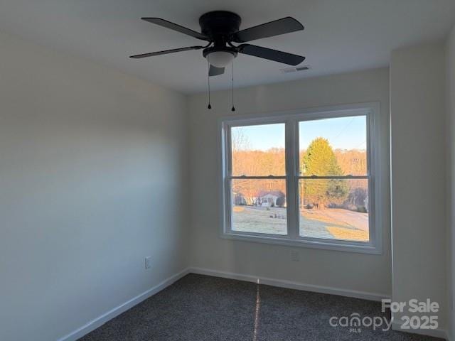 unfurnished room with ceiling fan and dark colored carpet