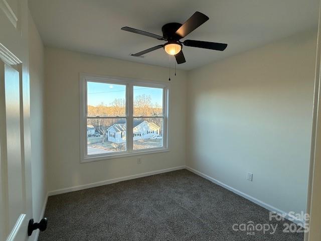 carpeted empty room featuring ceiling fan