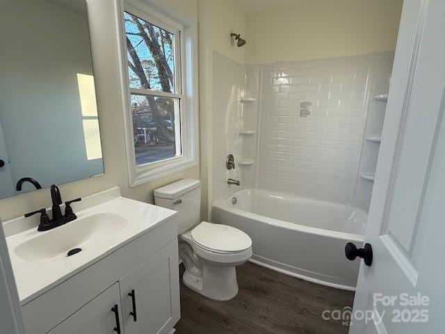 full bathroom with vanity, hardwood / wood-style flooring, toilet, and tiled shower / bath