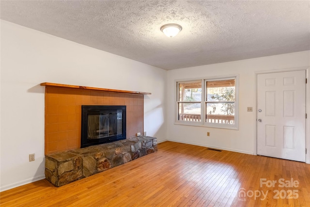 unfurnished living room with wood-type flooring and a textured ceiling