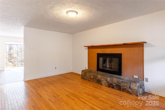 unfurnished living room with hardwood / wood-style floors and a textured ceiling