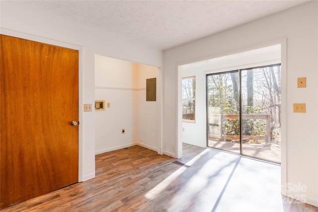 doorway to outside with hardwood / wood-style floors and a textured ceiling