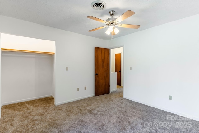 unfurnished bedroom with ceiling fan, light colored carpet, a closet, and a textured ceiling