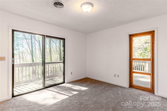 carpeted empty room with a textured ceiling