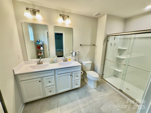 bathroom with toilet, vanity, and a shower with shower door