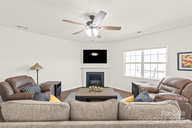 living room with dark wood-type flooring and ceiling fan