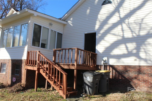 rear view of property with a sunroom and a deck